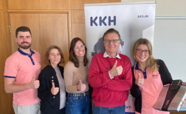 Gesundheitstag bfz Augsburg Fünf Personen vor einem Banner mit der Aufschrift „KKH“. Alle zeigen mit den Daumen nach oben.