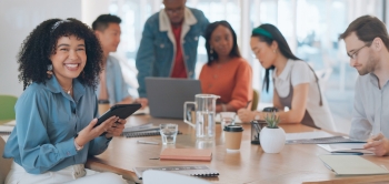 Jobturbo Thumbnail: Eine diverse Gruppe von Menschen unterschiedlicher Herkunft sitzt an einem Tisch und arbeitet beziehungsweise lernt gemeinsam.