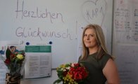 Einer der Absolventinnen, Milijana Djurica mit den Blumen und Zertifikat in der Hand, die sie erhalten hat.