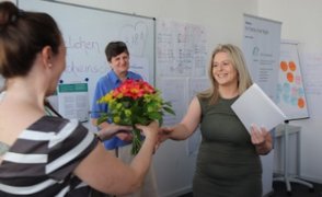 bfz-Seminarleiterin Alexandra Trick überreicht der Absolventin Milijana Djurica Blumen und das Abschlusszertifikat