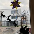 Rentiere mit Schlitten aus Papier kleben am Fenster