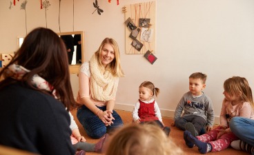 Kinder und Erwachsene in einem Kindergarten.