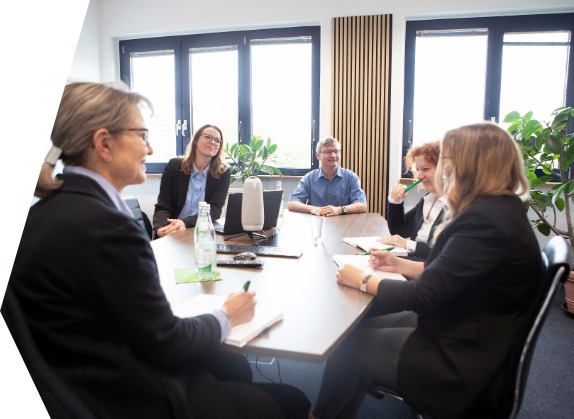 Team bfz Bayreuth bfz Bayreuth: Eine Gruppe von Geschäftsleuten sitzt an einem Konferenztisch und unterhält sich.