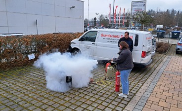 Übungssituation: Eine junge Frau löscht mit einem CO2-Feuerlöscher einen Brand.