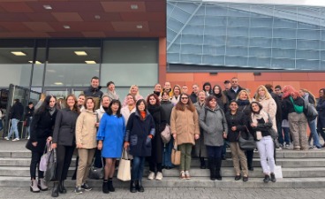 Teilnehmer*innen zweier Deutschkurse des bfz Standortes Hof stehen auf der Treppe vor dem Gebäude, in dem die Hofer Ausbildungsmesse stattfand.