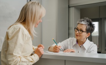 Zwei Frauen an der Anmeldung einer Arztpraxis