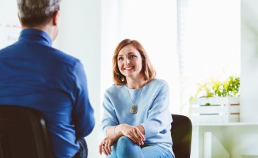 Eine Frau in einem Coachinggespräch mit einem Mann.